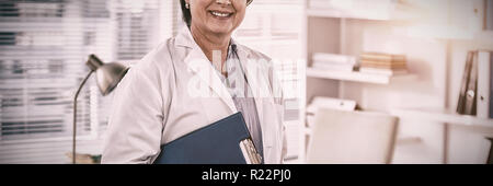 Ritratto di una donna sorridente medico tenendo negli appunti Foto Stock