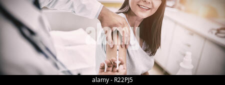 Medico dando una iniezione al paziente Foto Stock