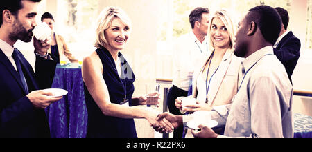 I dirigenti aziendali a interagire gli uni con gli altri mentre un caffè Foto Stock
