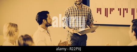 I colleghi ad applaudire un collega dopo la presentazione Foto Stock