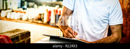 Pizza consegna uomo prendendo un ordine per telefono Foto Stock