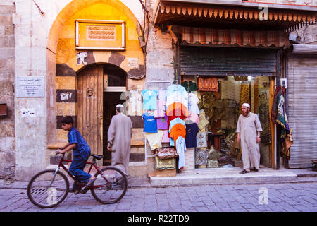 Aleppo, Governatorato di Aleppo, Siria : un bambino su una bicicletta sorge da una moschea in uno stretto vicolo del centro storico. Foto Stock