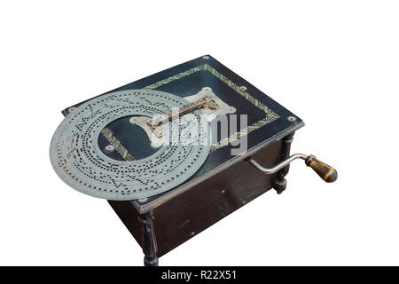 Old-time music box in legno nero con scatola di metallo perforato disco su uno sfondo bianco. Foto Stock