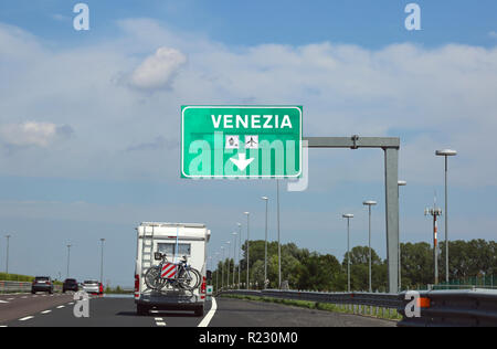 Italiano grande cartello stradale che indica a Venezia e un camper sulla strada. Mezzi di Venezia Venezia Foto Stock