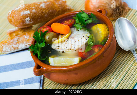 Far bollire il pollock testa per il brodo. Aggiungere le patate, carote, scalogno, mais e filetti o bistecca pollack 200 gramm, sale, pepe. Portare il forno nel Foto Stock