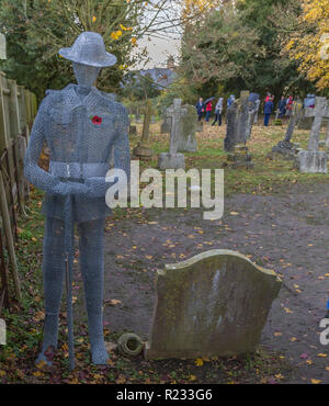 "Ghostlike' sculture (dall artista Jackie Lantelli) di soldati morti nella guerra mondiale uno accanto alle loro tombe nel cimitero di Slimbridge Foto Stock