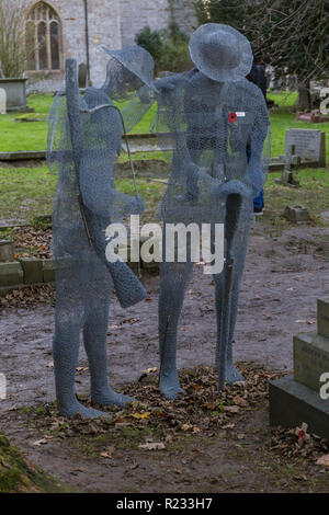 "Ghostlike' sculture (dall artista Jackie Lantelli) di soldati morti nella guerra mondiale uno accanto alle loro tombe nel cimitero di Slimbridge Foto Stock