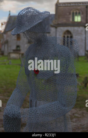 "Ghostlike' sculture (dall artista Jackie Lantelli) di soldati morti nella guerra mondiale uno accanto alle loro tombe nel cimitero di Slimbridge Foto Stock