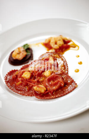 A forma di cuore ad pasta fresca ripiena condita con crema di gamberetti. San Valentino Piatto di festa. Foto Stock