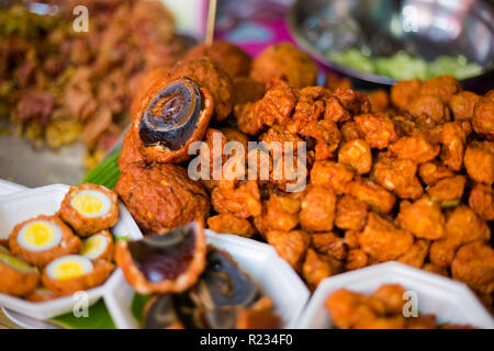 Fresche fritte anatra asiatica secolo le uova in pastella sul mercato locale a Bangkok. Cucina tailandese tradizionale fatta di ingredienti freschi. Foto Stock