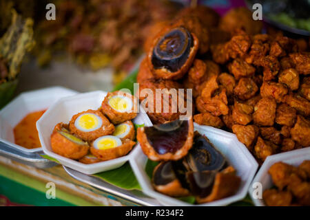 Fresche fritte anatra asiatica secolo le uova in pastella sul mercato locale a Bangkok. Cucina tailandese tradizionale fatta di ingredienti freschi. Foto Stock