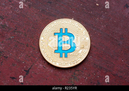 Golden cryptocurrency bitcoin blu su sfondo rosso, cloose fino. Foto Stock