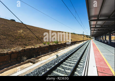 Linea ferroviaria, deserte stazione ferroviaria, piattaforma vuota, bel cielo azzurro, binari del treno Foto Stock