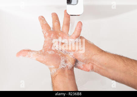 Close-up di uomo che pulisce le mani sotto acqua come igiene personale concetto Foto Stock