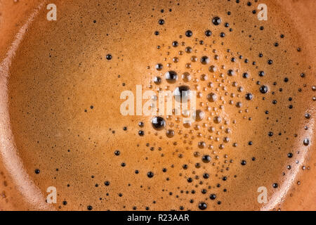 La schiuma del caffè in tazza di primissimo piano. Tessitura macro e sfondo Foto Stock