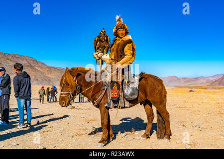 ULGII, MONGOLIA - Ottobre 6, 2018 : Golden Eagle Festival. Il Golden Eagle Hunter in abiti tradizionali di pelliccia di volpe con eagle sulla sua mano in com Foto Stock