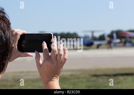 MAYSKE, Ucraina - 24 agosto 2018: Donna prende le immagini di air show con lo smartphone, aprire Festival in Ucraina Il Giorno Di Indipendenza 'Vilne Nebo 2018' / 'fr Foto Stock