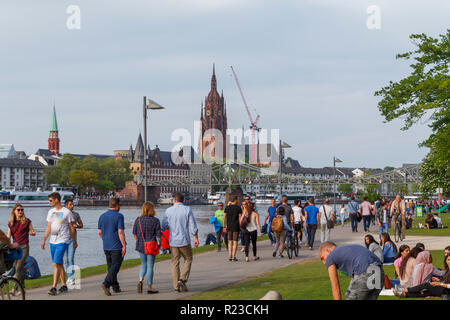 Per coloro che godono di una giornata di sole accanto al fiume principale della città di Francoforte, Germania Foto Stock