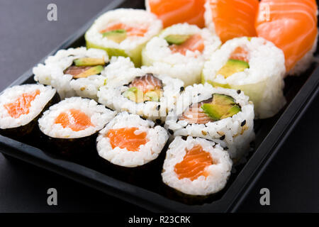Sushi pack con il nigiri e maki su sfondo nero Foto Stock