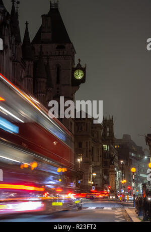 London, England, Regno Unito - 15 Ottobre 2018: un rosso double-decker bus luce lascia tracce come esso si muove lungo la strada della flotta al di fuori della Royal Courts of Justice Foto Stock