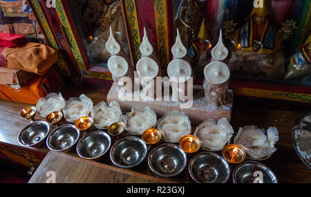 India, Himachal Pradesh, Manali, Gandhan Thekchokling Gompa, 08/09/2010: candele e riso su un buddista ara votiva Foto Stock