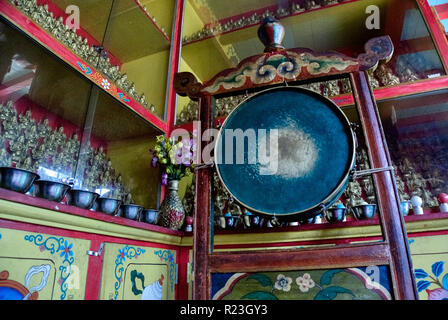 India, Himachal Pradesh, Manali, Gandhan Thekchokling Gompa, 08/09/2010: tradizionale gong buddista circondato da casi di vetro contenente piccole statue Foto Stock