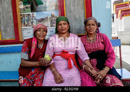 India, Himachal Pradesh, Manali, Gandhan Thekchokling Gompa, 08/09/2010: tre donne seduta su una panchina tenere mani e uno di essi mostra un Apple Foto Stock