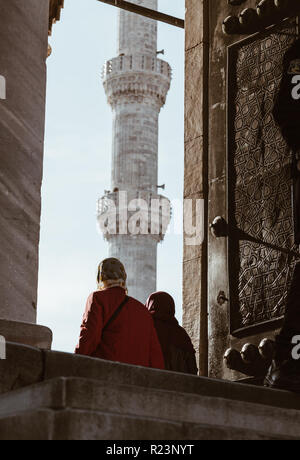 La donna musulmana di entrare nell'ingresso della Moschea Blu di Istanbul - Turchia Foto Stock