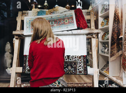 Donna al lavoro su tradizionale turca la tessitura dei tappeti in Istanbul TURCHIA Foto Stock