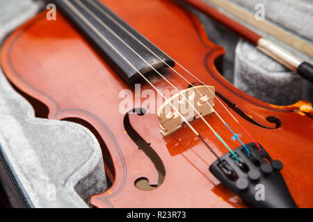 Marrone Vintage violino con archetto giacente in un caso closeup indoor Foto Stock