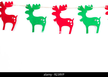 Natale in rosso e in verde le renne in fila. Isolato su sfondo bianco. Lo spago. Copia dello spazio sul fondo. Foto Stock