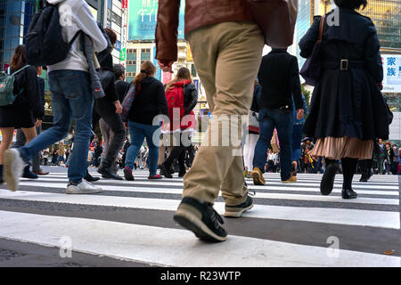 Basso angolo vista della folla a piedi attraverso la traversata di Shibuya, Tokyo, Giappone, Asia Foto Stock