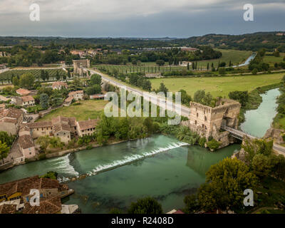 Panorama dell'antenna del medievale ponte fortificato di Valeggio sul Mincio vicino a Verona con il Borghetto e una piccola cascata, verde acqua, cielo molto nuvoloso Foto Stock