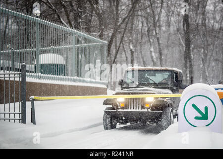 Auto SUV si è fermato a inserimento automatico cancello durante la nevicata. Veicolo gateway di accesso al sistema. Stagione di Blizzard a winer sulla strada della citta'. Foto Stock