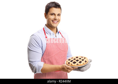 Uomo bello con grembiule tenendo una torta di ciliegie isolati su sfondo bianco Foto Stock