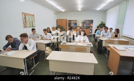 Gli studenti in aula siedono a banchi di scuola prima della lezione. Scuola russa. Foto Stock