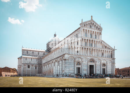 Foto orizzontale con la famosa Piazza del Duomo. Edificio è posto sulla Piazza dei Miracoli con la torre pendente. L'erba è già marrone e sky Foto Stock