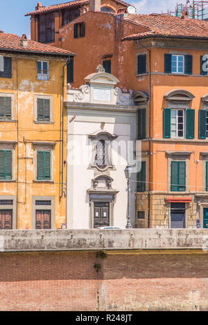 Foto verticale con divertenti casa stretta. Un edificio bianco è compreso tra gli altri due. Casa è nella famosa città italiana Pisa in Toscana. Casa è sul lato di riv Foto Stock