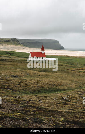 La piccola chiesa Breidavik e passi nel tetro basse nubi Islanda paesaggio del Westfjords. Foto Stock