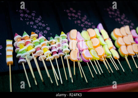 Fresco di zucchero asiatici rivestite di gelatina colorata bastoni sul mercato locale in Krabi. Cucina tailandese tradizionale fatta di ingredienti freschi. Foto Stock