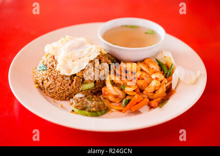 Preparati freschi fritto malesiano set di pollo servito con riso, uova e minestra chiaro brodo in un ristorante locale a Kuala Kangsar. Tradizionale cucina asiatica Foto Stock