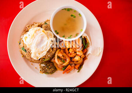 Preparati freschi fritto malesiano set di pollo servito con riso, uova e minestra chiaro brodo in un ristorante locale a Kuala Kangsar. Tradizionale cucina asiatica Foto Stock