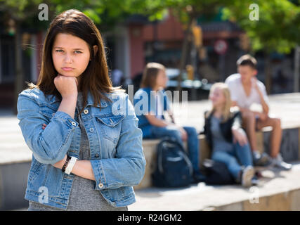 Ritratto di offeso outcasted ragazza adolescente di essere assaliti da altri ragazzi all'aperto Foto Stock