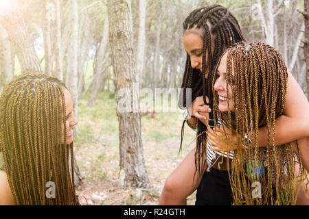 Tre giovani e belle ragazze, con capelli intrecciati, divertendosi Foto Stock