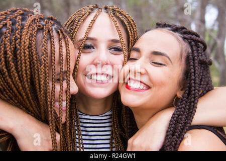 Tre giovani e belle ragazze, con capelli intrecciati, divertendosi Foto Stock