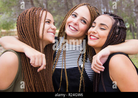 Tre giovani e belle ragazze, con capelli intrecciati, divertendosi Foto Stock