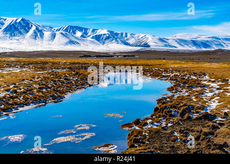 Vista della bellissima montagna di neve con la steppa giallo e il blu del cielo in Mongolia nel mese di ottobre 2018 Foto Stock