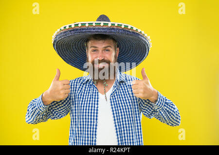 Ragazzo messicano felice vestito festivo pronto a festeggiare. Uomo Barbuto allegro guy indossare sombrero Mexican Hat sfondo giallo. Messicano il concetto di partito. Celebrare la tradizionale vacanza messicana. Consente di divertirsi. Foto Stock