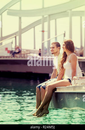 Amare giovane in abiti casual a prendere il sole sulla banchina di ormeggio Foto Stock