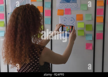 Executive femmina facendo clic su Foto di sticky notes Foto Stock